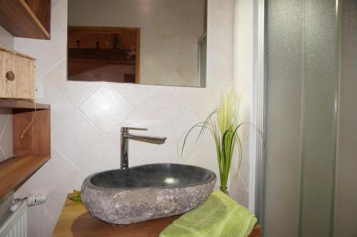 a bathroom with a large stone sink on a counter at Auberge du Thiollet in Montromant