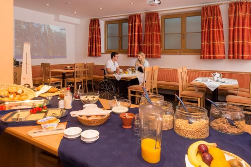 a man and woman sitting at a table with food at Haus Renate in Kaunertal