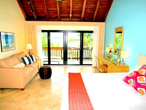 a living room with a bed and a couch at Luxury Beachfront Duplex Villa on Sapphire Beach IV in Frydendal