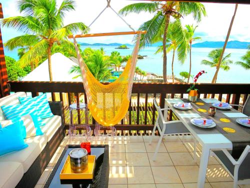a hammock on a balcony with a view of the ocean at Luxury Beachfront Duplex Villa on Sapphire Beach IV in Frydendal