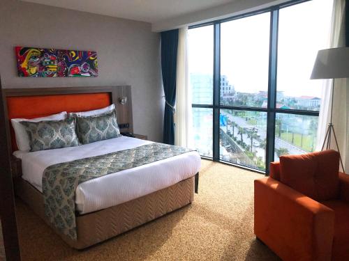 a hotel room with a bed and a large window at King Sky Tower Hotel in Batumi