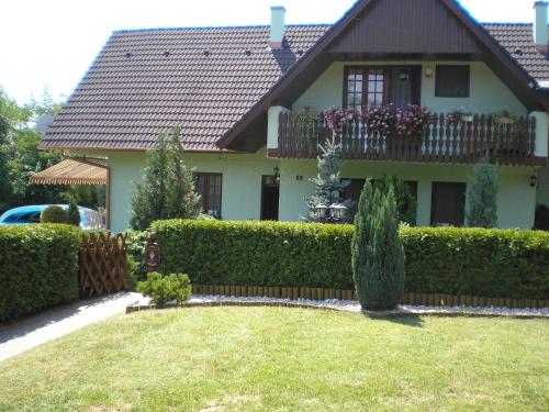 a house with a fence in front of a yard at Király Nyaraló in Fonyód