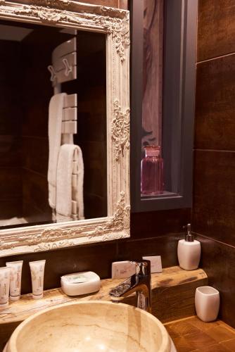 a bathroom with a sink and a mirror at Hôtel Le Manoir des Montagnes in Les Rousses