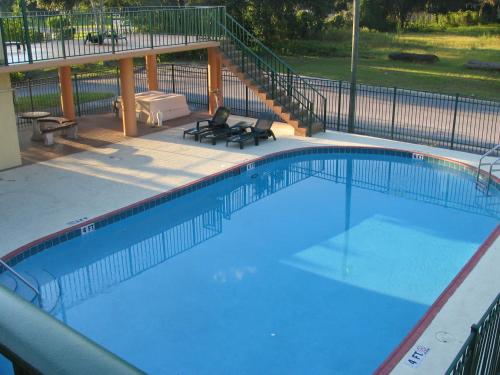 a large swimming pool with two chairs and a table at Ambassador Inn in Kissimmee