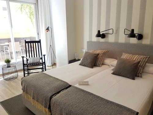 a bedroom with a large bed and a chair at Hotel Boutique Balandret in Valencia