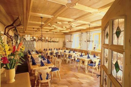 a large room with tables and chairs and flowers at Gasthof & Hotel Jägerwirt in Aufhofen