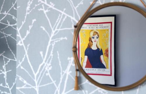 a mirror on a wall with a picture of a woman at La Galerie in Toulouse