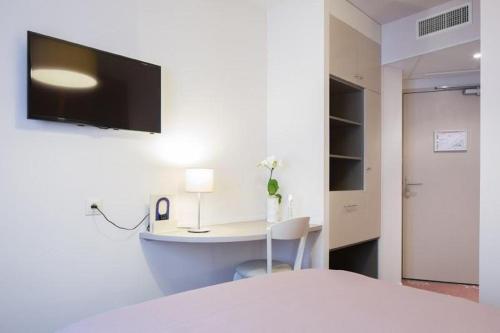 Una televisión o centro de entretenimiento en Hôtel Ours Blanc - Wilson