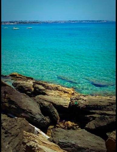 a view of the ocean from a rocky shore at Rudy Arenaile in Arenella