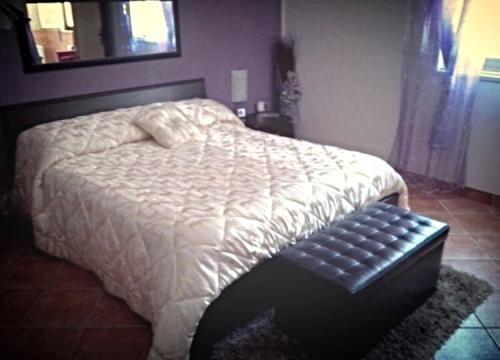 a bedroom with a bed with a black ottoman next to it at Rudy Arenaile in Arenella