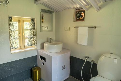 a bathroom with a sink and a toilet at The Seven Sisters Farm in Kodaikānāl