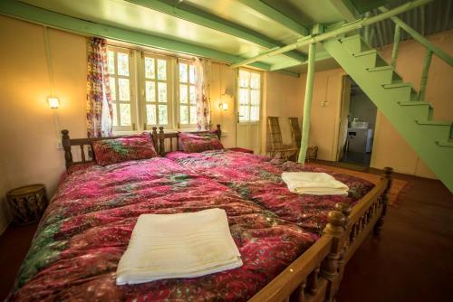 a bedroom with a large bed with two towels on it at The Seven Sisters Farm in Kodaikānāl