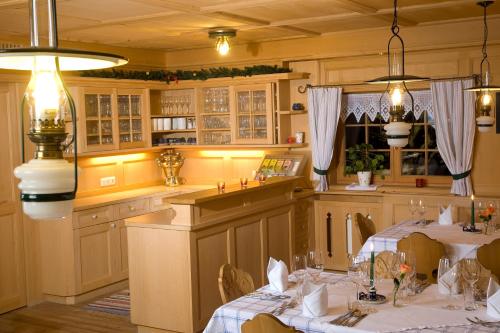 a dining room with two tables and a kitchen at Gämsle Hotel, Wirtshaus & mehr in Schoppernau