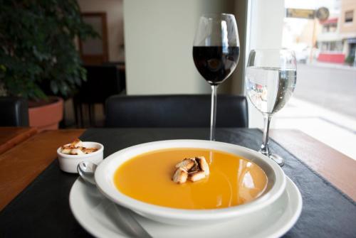 a bowl of soup and a glass of wine on a table at Hotel Gran Madryn in Puerto Madryn