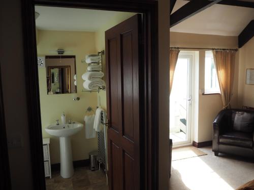 a bathroom with a sink and a mirror and a door at The Smugglers in Penzance