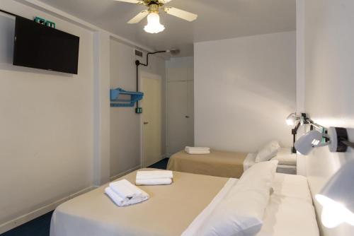 a room with two beds and a flat screen tv at Casa Urbana Hotel in Cordoba