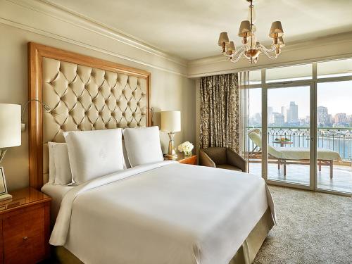 a bedroom with a large bed and a large window at Four Seasons Hotel Cairo at Nile Plaza in Cairo
