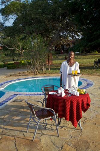 a man sitting at a table with a plate of food at Ashnil Aruba Lodge in Tsavo