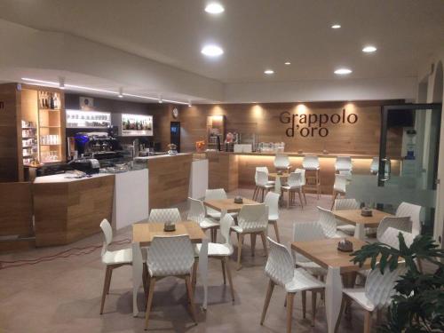 a restaurant with tables and chairs and a counter at Hotel Il Grappolo D'Oro in Monforte dʼAlba