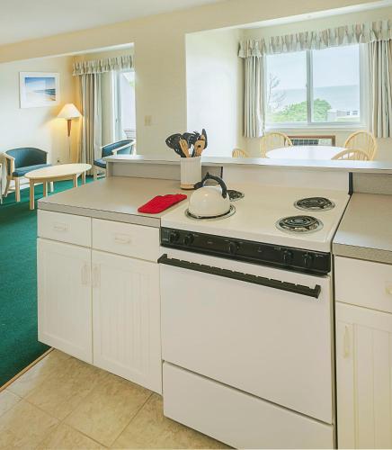 a kitchen with a stove and a counter top at Surfcomber On The Ocean in South Yarmouth
