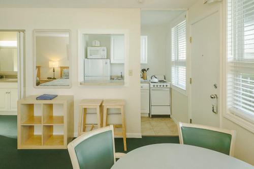 a kitchen and dining room with a table and chairs at Surfcomber On The Ocean in South Yarmouth