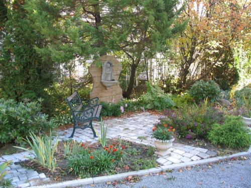 a bench sitting in the middle of a garden at Aux petits oiseaux in Baie-Saint-Paul