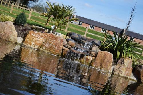 a waterfall in the middle of a pond with rocks at The White Hart Inn in Alfreton