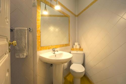 a bathroom with a sink and a toilet and a mirror at Angola Apartment - 8Bedrooms in Lisbon