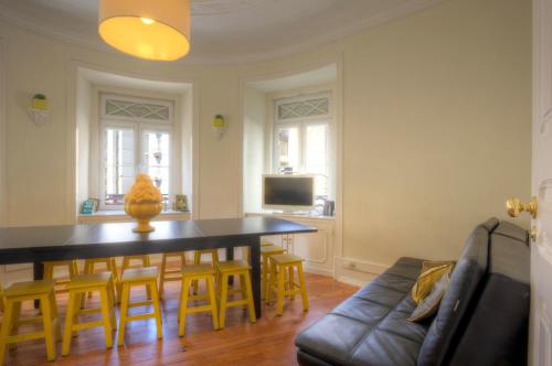 a living room with a table and chairs and a couch at Angola Apartment - 8Bedrooms in Lisbon