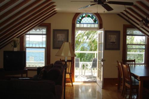 a living room with a couch and a table and windows at Boathouse Country Inn in Rockport