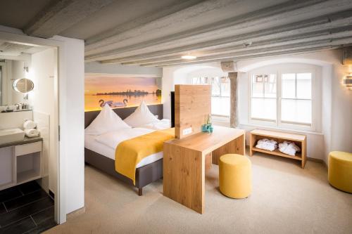 a bedroom with a bed and a desk in a room at Hotel Alte Schule in Lindau