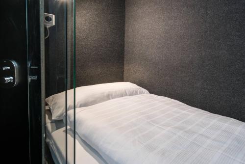 a bed in a room with a glass door at BoxHotel Göttingen (App Based Hotel) in Göttingen