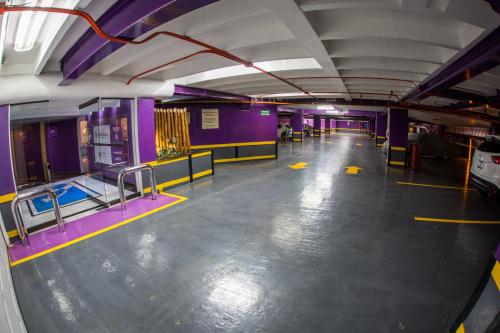 a large room with purple walls and a large floor at WeEnjoy Hotels Grand Prix Aeropuerto CDMX in Mexico City