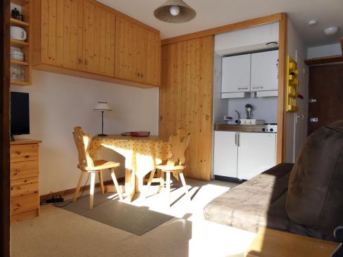 un salon avec une table et des chaises et une cuisine dans l'établissement Résidence Roc De Tougne, à Méribel