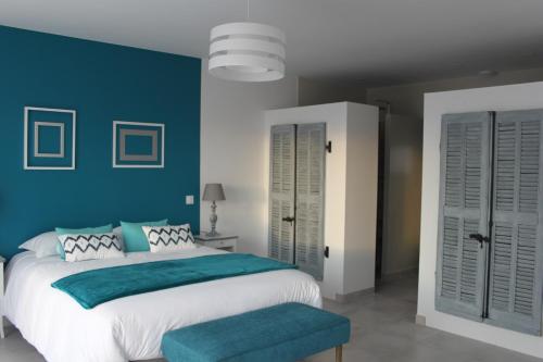 um quarto com uma cama grande e paredes azuis em Au Fil des Cévennes em Saint-Jean-de-Maruéjols-et-Avéjan