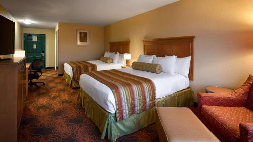una habitación de hotel con 2 camas y una silla en Best Western Plus Waco North, en Waco