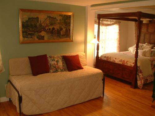 a living room with a couch and a bed at Truman Gillet House B & B in Granby