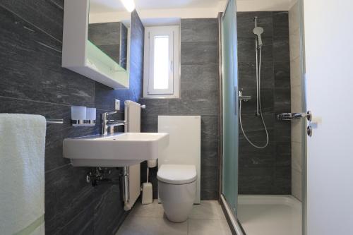 uma casa de banho com um lavatório, um WC e um chuveiro em Osteria Ticino by Ketty & Tommy em Ascona
