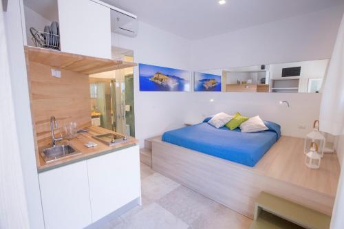 a bedroom with a blue bed and a sink at A Tonnara in Cefalù