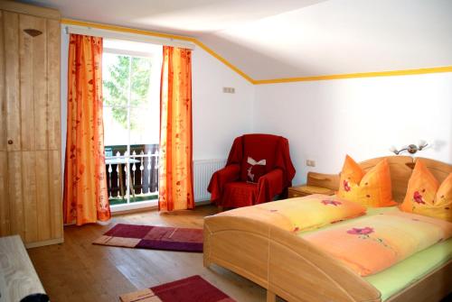 a bedroom with a bed and a chair and a window at Haus Schöffau in Strobl