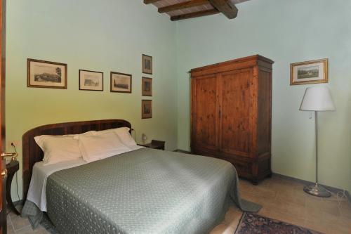 1 dormitorio con 1 cama y armario de madera en Bed and Breakfast Mugello en Vicchio