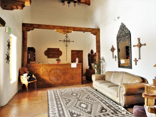 a living room with a couch and a cross on the wall at Casa Benavides Inn in Taos