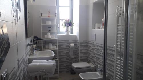 a bathroom with two sinks and a toilet and a window at Affittacamere Erbagatta in Erba