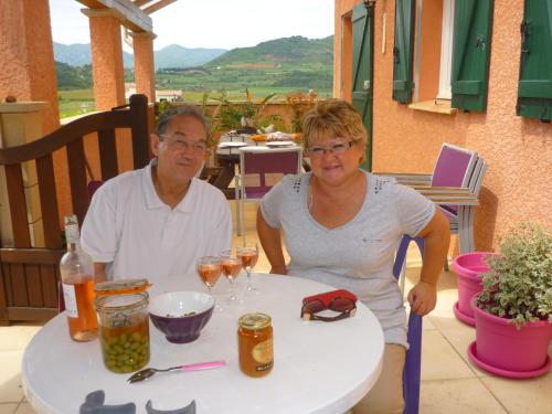 un hombre y una mujer sentados en una mesa con copas de vino en Le gite de Cristal proche Bugarach, en Granès