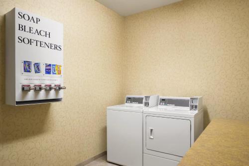 a laundry room with a washing machine and a sign at Country Inn & Suites by Radisson, St Peters, MO in Saint Peters