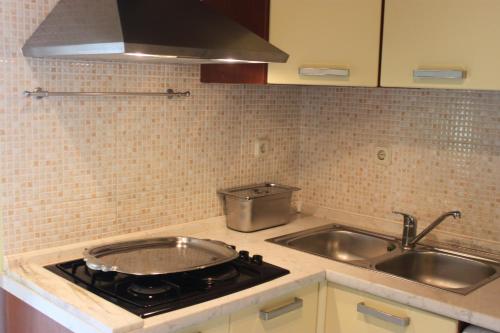 a kitchen with a stove top and a sink at Oasis Apartments in Sutivan