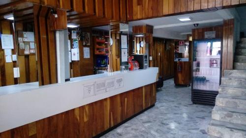 ein Restaurant mit einer Theke und einem Kühlschrank in der Unterkunft Hotel Patria in Mexiko-Stadt