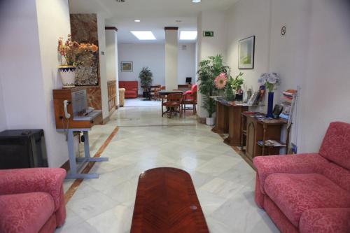 Sala de estar con 2 sofás y mesa en Hotel El Coloso en Jerez de la Frontera
