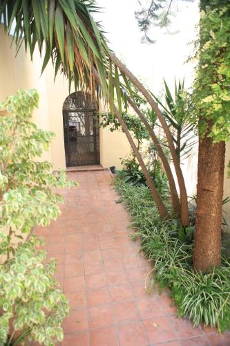 a brick walkway leading to a building with a gate at Hotel El Coloso in Jerez de la Frontera