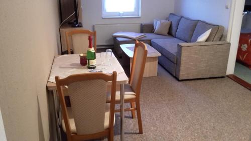 a small living room with a table and a couch at Pension Lemke in Polchow
